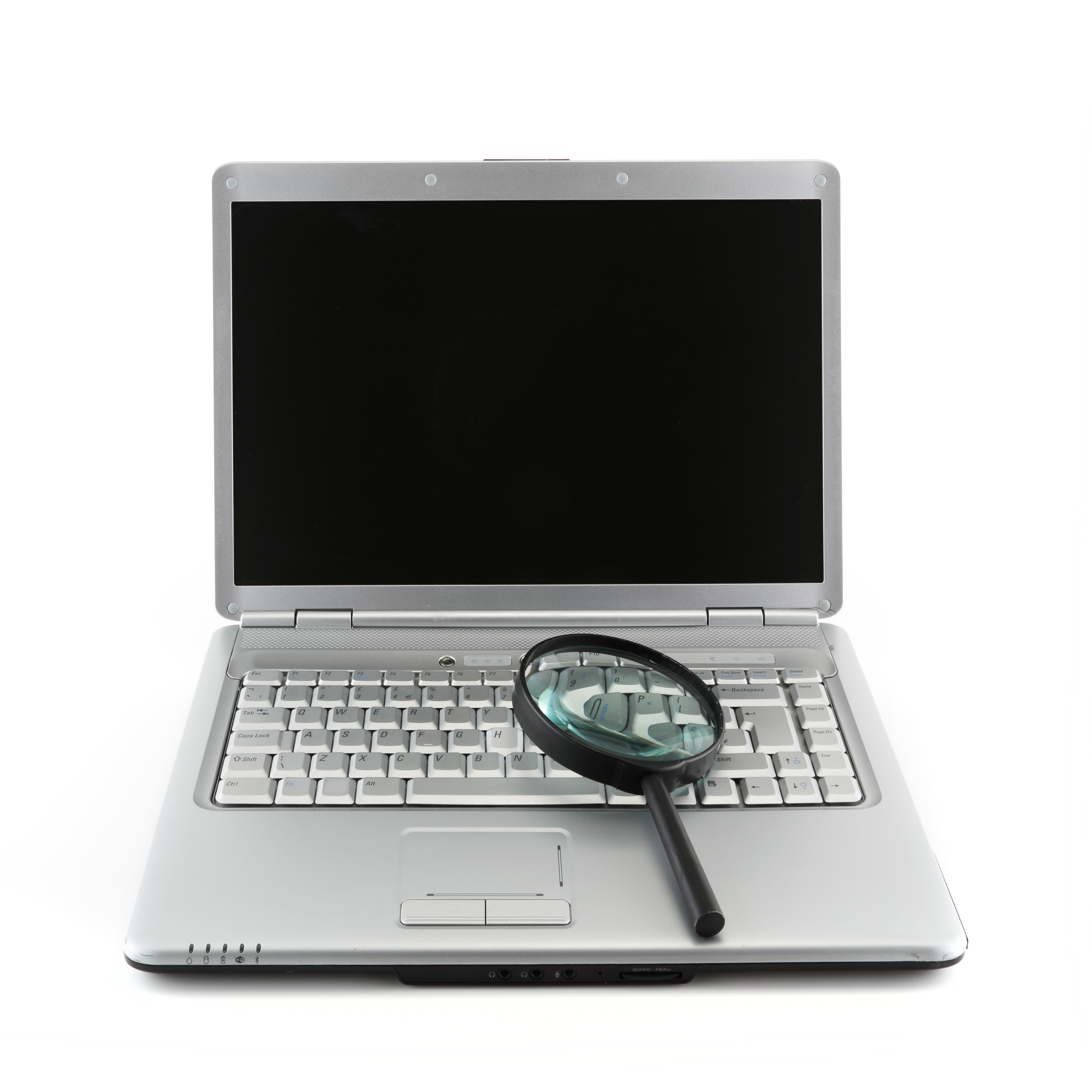 Open laptop with magnifying glass sitting on keyboard
